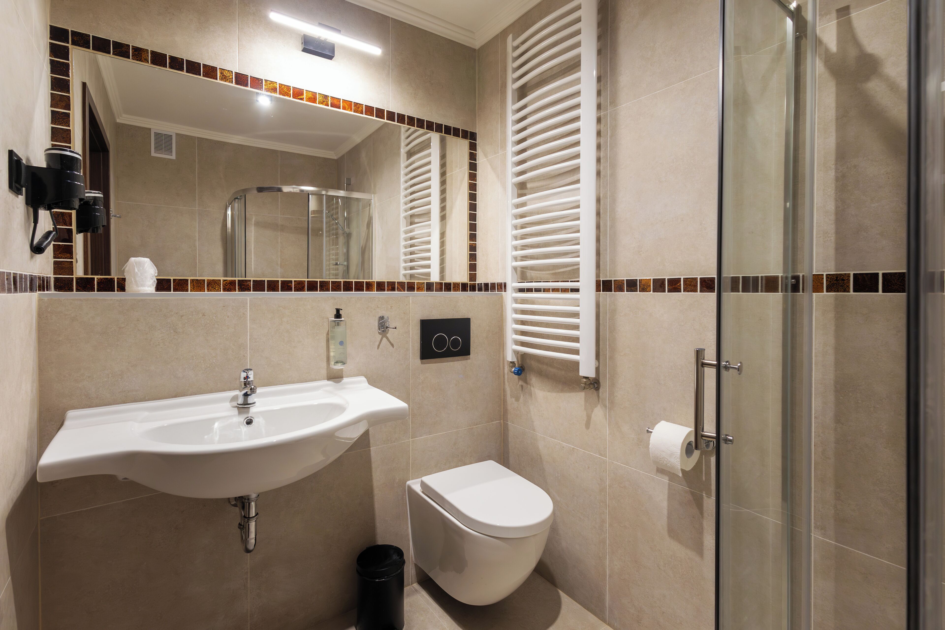A modern bathroom with a sink, toilet, and glass shower enclosure.