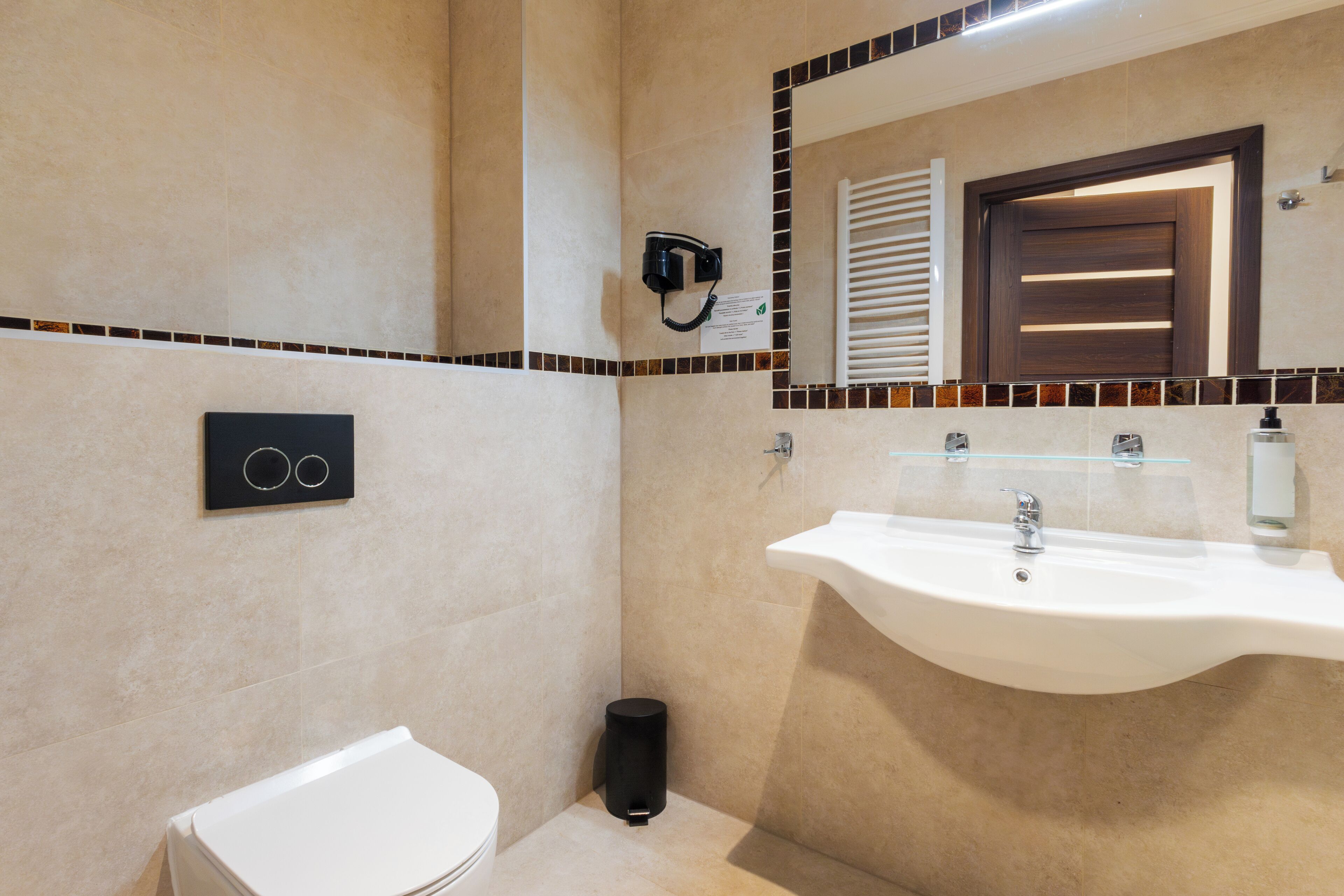 A bathroom with a white sink, a mirror, and a toilet.
