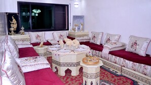 A traditional room with a sofa set, a small table with a tray, and a decorative item on the wall. - Luxury & Comfort apartment in the center, close to all amenities (Marrakesh)