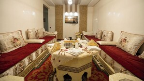 A room with two sofas facing each other, a small table with a decorative centerpiece, and a television mounted on the wall. - Luxury & Comfort apartment in the center, close to all amenities (Marrakesh)