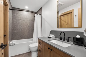 Une salle de bain moderne avec une baignoire, des toilettes et un lavabo.
