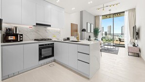 A modern kitchen with a built-in oven, a microwave, and a coffee maker. - StayShort - Sophisticated JVC Apartment Sleeps 4 with Balcony (JVC)