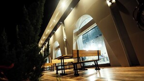 A spacious interior with wooden benches and large windows. - A1 Tiger Resort (Chimur)