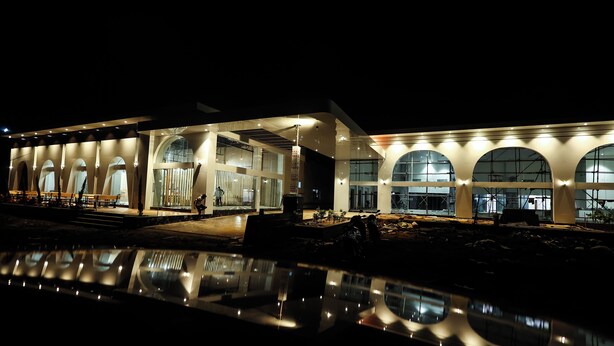 A modern building with arched windows and a reflective water feature in front. - A1 Tiger Resort (Chimur)