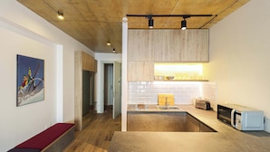 A modern kitchen with a wooden ceiling, a built-in microwave, and a countertop with a toaster. - New Gudauri Cozy Studio By Wehost (Gudauri)