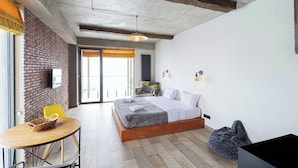 A modern hotel room with a large bed, a small table, and a chair. - Studio near Gondola in New Gudauri by Wehost (Gudauri)