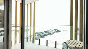 A balcony with a view of a parking lot and a wooden chair. - Studio near Gondola in New Gudauri by Wehost (Gudauri)