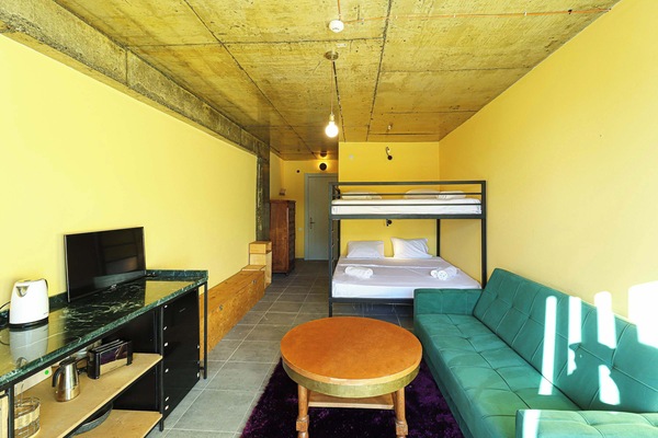 A bright, open layout showcasing the king-size bunk bed, ample storage, and cozy seating area - all conveniently within arm’s reach.