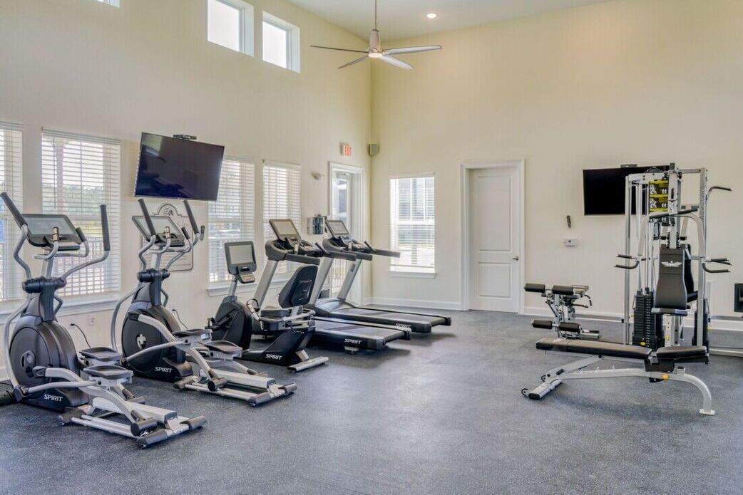 A gym with treadmills, elliptical machines, and a weight machine.