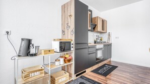 Una cocina moderna con microondas, cafetera y cajas de almacenamiento de madera.