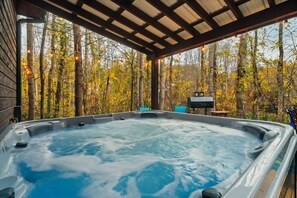 Ein Whirlpool in einer überdachten Außenbereich mit Blick auf einen Wald.