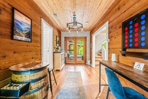 Ein Holzinterieur mit Barbereich, einem Esstisch und Blick ins Freie.