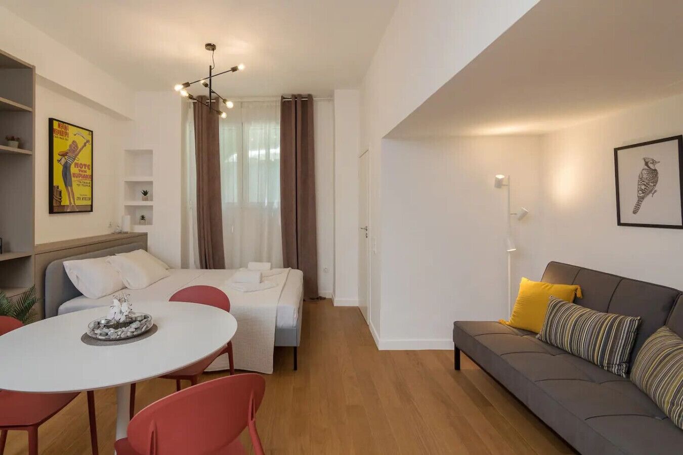 Een moderne woonkamer met een bank, een eettafel en een keukenhoek.