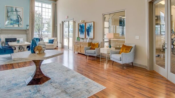 A spacious living room with a fireplace, a dining area, and a large window providing natural light. - Landing Furnished Apartments near Barfield (Murfreesboro)