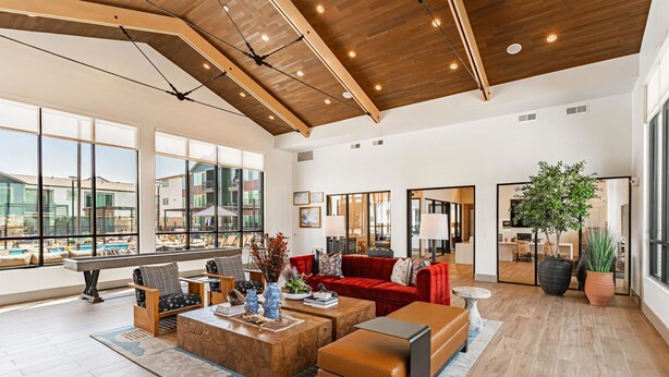 A spacious living area with a large window, wooden ceiling, and modern furniture. - Landing Apartments Denver - Firestone (Longmont)