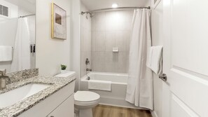 A modern bathroom with a shower, toilet, and sink. - Landing Apartments Denver - Firestone (Longmont)