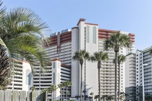 Ein mehrstöckiges Hotel mit modernem Design, das Balkone und eine zentrale, vertikale Struktur aufweist.