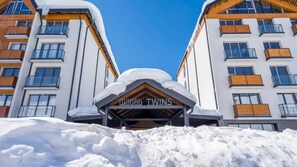 Een hotelentree met een bord waarop '0806 Twins' staat en een met sneeuw bedekte dak.