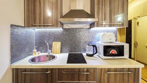 A kitchen with a sink, a microwave, and a kettle. - New Gudauri Redco Apt. | Comfort by Wehost (Gudauri)