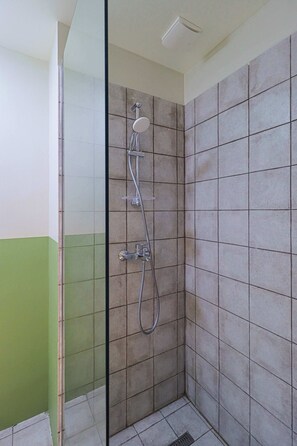 A shower with a glass door, tiled walls, and a green accent wall. - Studio in Redco Gudauri Ski Paradise (Gudauri)
