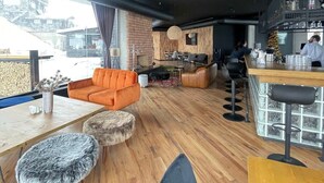 Ein modernes Interieur mit Barbereich, Sitzgelegenheiten und Blick ins Freie.