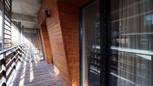 Eine Holzfassade mit Glastür und Metallgeländer.