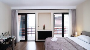 Ein Hotelzimmer mit Bett, Schreibtisch, Stuhl, Kamin und einer Schiebetür zum Außenbereich.