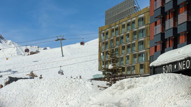 A modern building with a ski lift in the background. - Neo Gudauri Sylish Studio - Managed By Wehost (Gudauri)