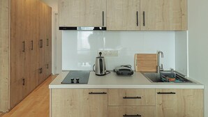 Una cocina moderna con armarios de madera, horno empotrado y fregadero.