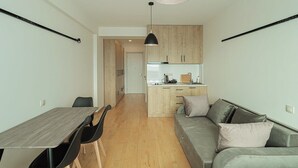 Un espacio habitable compacto con comedor, kitchenette y sofá.