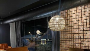 A modern living room with a leather sofa, a round coffee table, and a large floor lamp. - Marshall Gudauri 2 Room Apt - By Wehost (Gudauri)