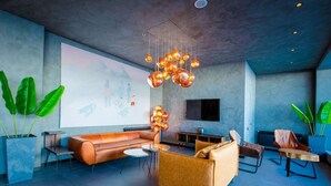 Uma sala de estar moderna com sofá, cadeiras, mesa de centro e luminária pendente única.