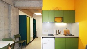 A compact kitchen with green cabinets, a white refrigerator, and a small sink. - Stylish Ski-In/Out Apt- Mountain Views - By Wehost (Gudauri)