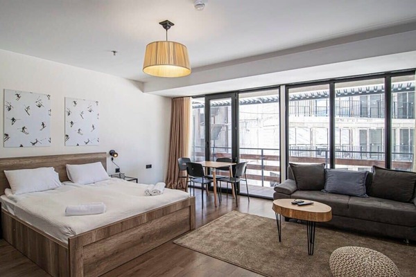 The living area features comfy sofas and a plush carpet for a warm, homey vibe.