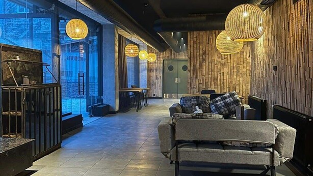 A modern interior with a wooden floor, a sofa, and hanging spherical lights. - Gudauri Cozy Studio - Adventure Ready - By Wehost (Gudauri)