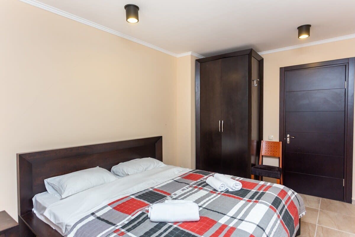 Quarto com uma cama, um guarda-roupa e uma porta.