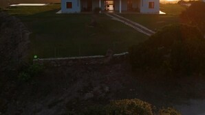 En toetages bygning med fladt tag, en overdækket veranda og et stort åbent område foran.