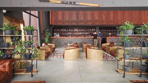 Un bar moderno con asientos, plantas en macetas y un soporte para esquíes.