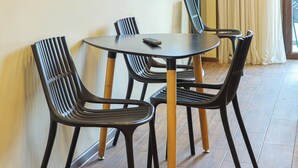 Comedor con una mesa redonda y cuatro sillas negras de patas de madera.