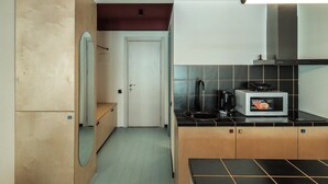 A compact kitchen with a microwave, coffee maker, and a small countertop. - Super Stylish Apartment In New Gudauri -By Wehost (Gudauri)