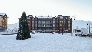 A hotel with a modern architectural design, featuring multiple floors and large windows. - Brand New Ski 1BR Apt In New Gudauri - By Wehost (Gudauri)