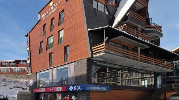 Een modern gebouw met een opvallend hoekig ontwerp, met gevels van baksteen en glas.