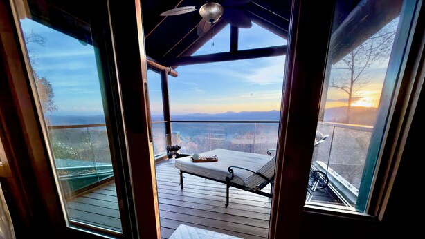 A balcony with a bed, a table with a tray, and a view of the landscape. - Sunrise Ridge – Lake & Mountain View Luxury (Blue Ridge)