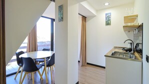Eine moderne Küche mit Einbauherd, kleinem Spülbecken und Fenster mit Blick auf einen Balkon.