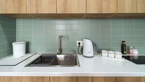 A kitchen with wooden cabinets, a stainless steel sink, a Bosch kettle, and a coffee maker. - Cozy & Family-friendly Apt. in Gudauri - by Wehost (Gudauri)