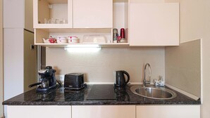 A compact kitchen with a built-in toaster, kettle, and a sink. - Charming New Gudauri Studio - by Wehost (Gudauri)