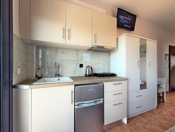 A compact kitchen with a dishwasher, a stove, and a microwave.