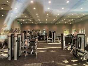 A gym with various exercise machines, a ceiling fan, and windows allowing natural light. -  Bright spacious 2 bedroom 2 bath condo In Heritage Landing a gated community (Punta Gorda)