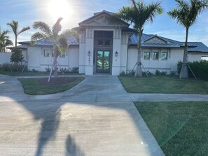 A modern building with a symmetrical facade, a central entrance, and a well-maintained lawn with palm trees. -  Bright spacious 2 bedroom 2 bath condo In Heritage Landing a gated community (Punta Gorda)