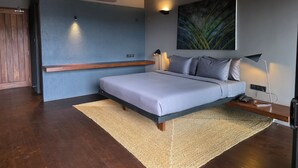 Ein modernes Schlafzimmer mit Bett, Nachttischlampe und einer Wand-Klimaanlage.